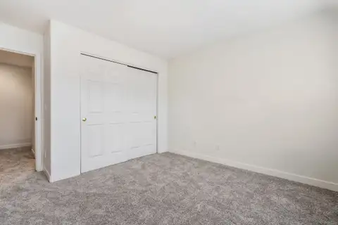 Bedroom with sliding closet doors and new carpet