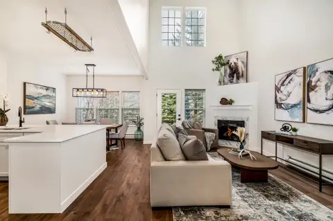 Great room looking past the kitchen island toward the dining area and fireplace