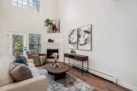 Living room with a tiled corner fireplace, French doors and clerestory windows
